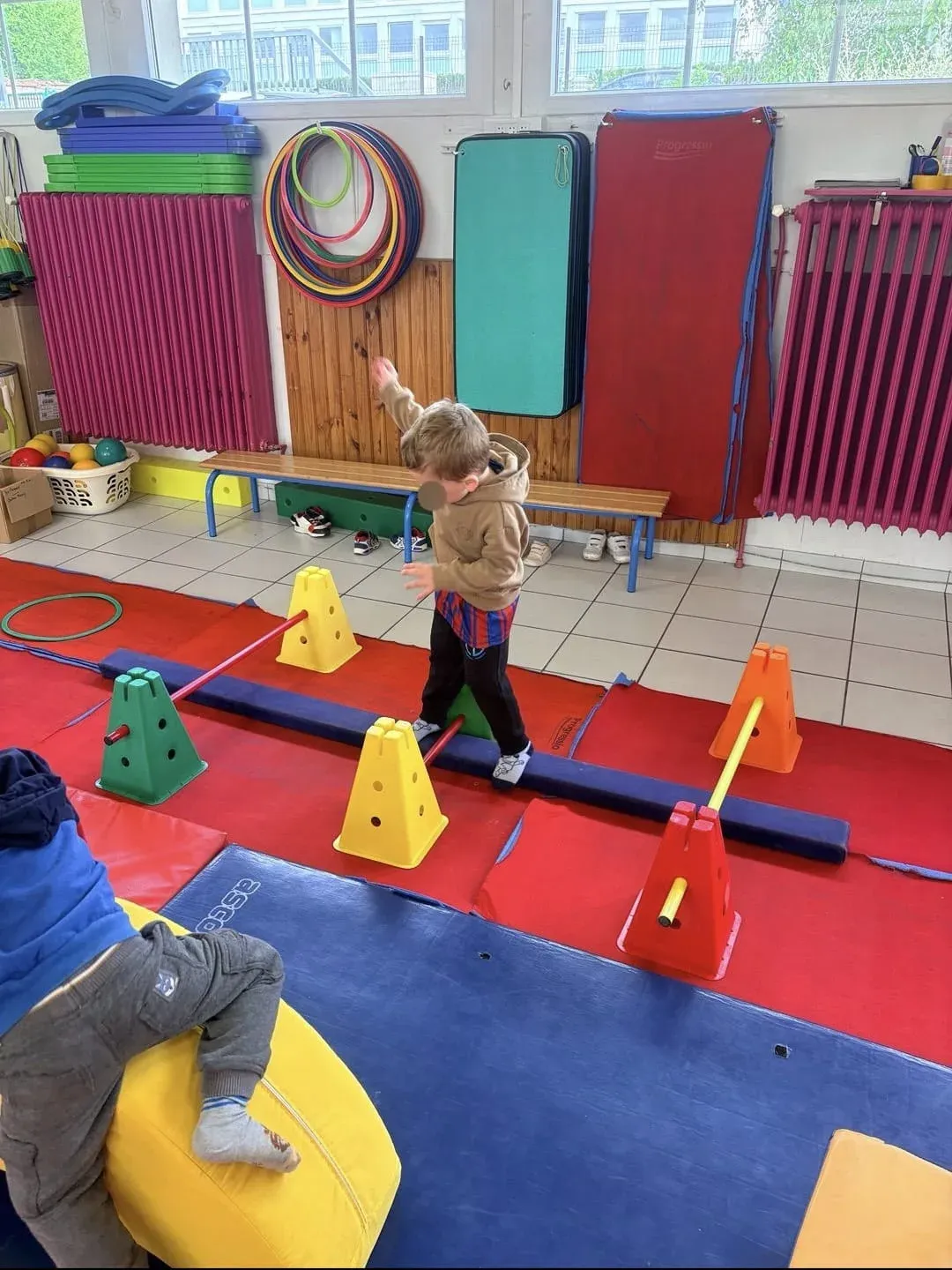 Enfant en équilibre sur une poutre de motricité